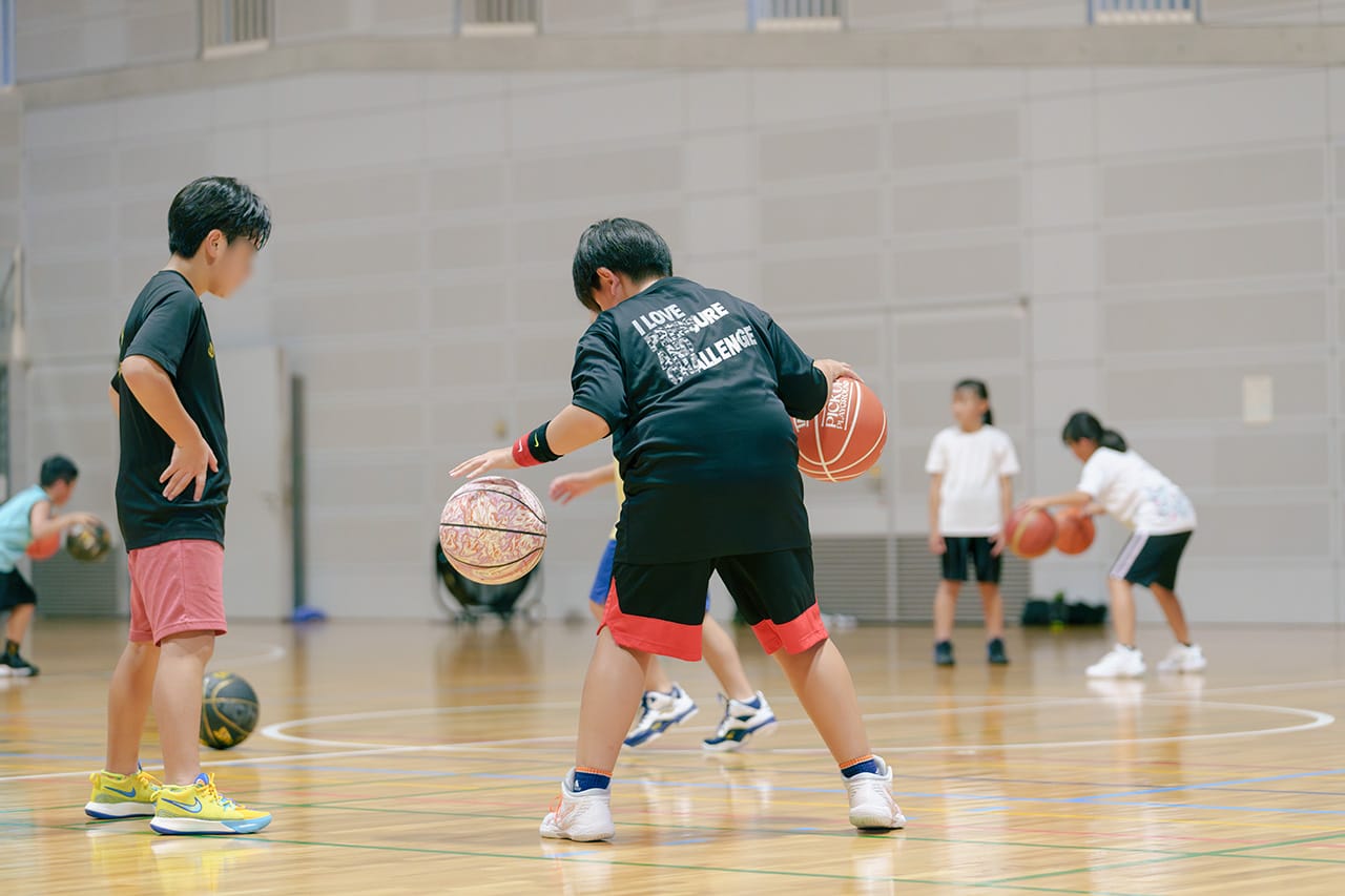 両手でドリブルをするツーボールドリブルを実践している生徒たち